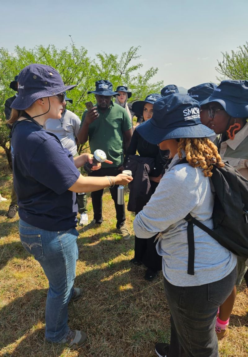 Students being shown the wet deposit sampler that collects rainfall samples that can be later analysed for chemicals contained in it.
