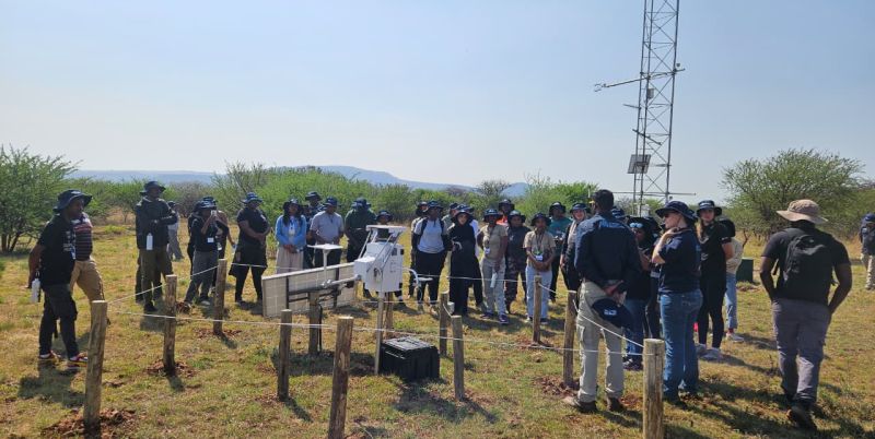 Students being shown the minivol instruments at the flux tower that measure dust particles in air over time.